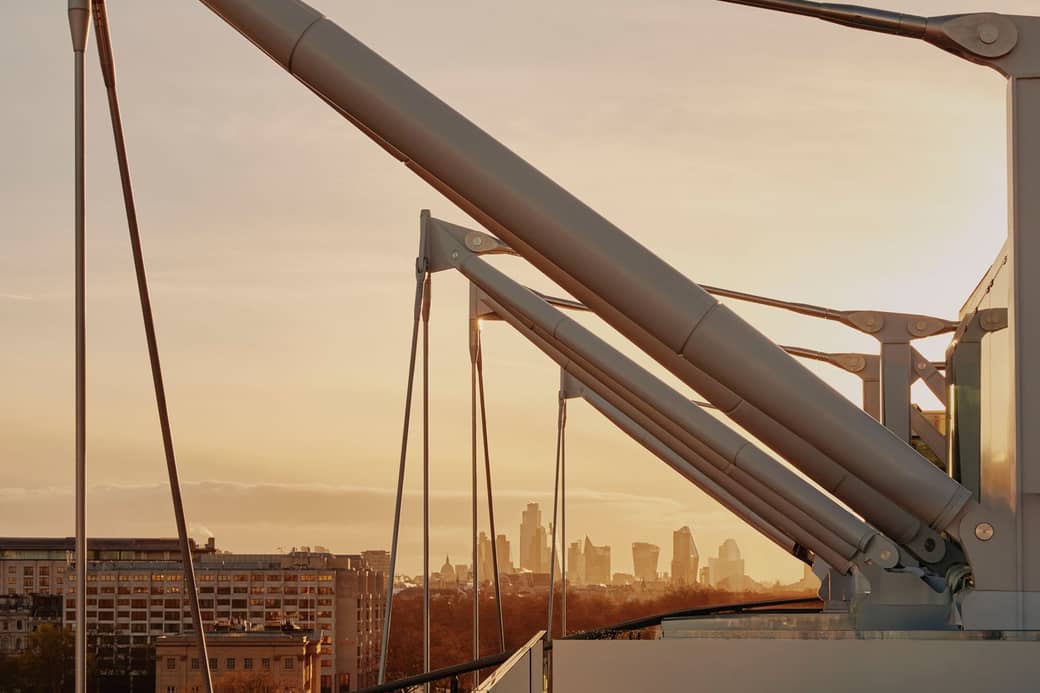Sunlit urban skyline framed by modern architectural details, blending precision engineering with a warm cityscape glow.